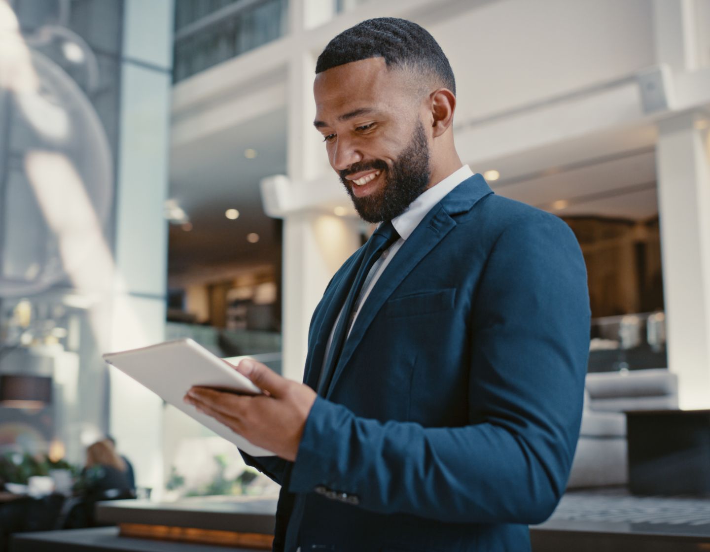 Man smiling looking at tablet in server room