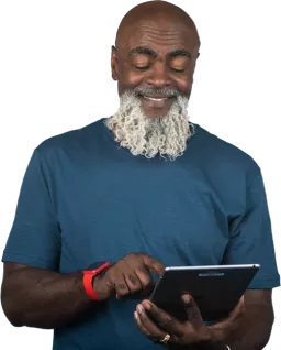 Older man smiling holding a tablet