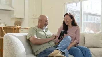 Older couple on couch reviewing Medicare options