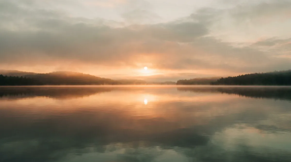 A serene, soft-focus golden sunrise reflecting peacefully over calm tranquil waters representing clarity and hope