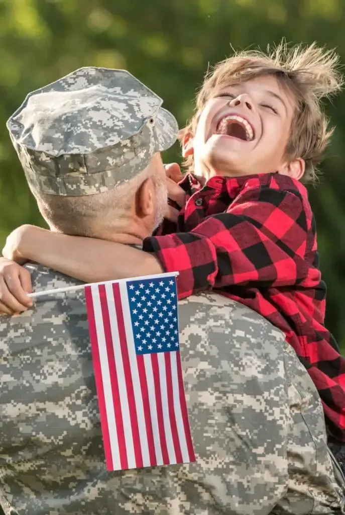 Soldier hugging child with flag