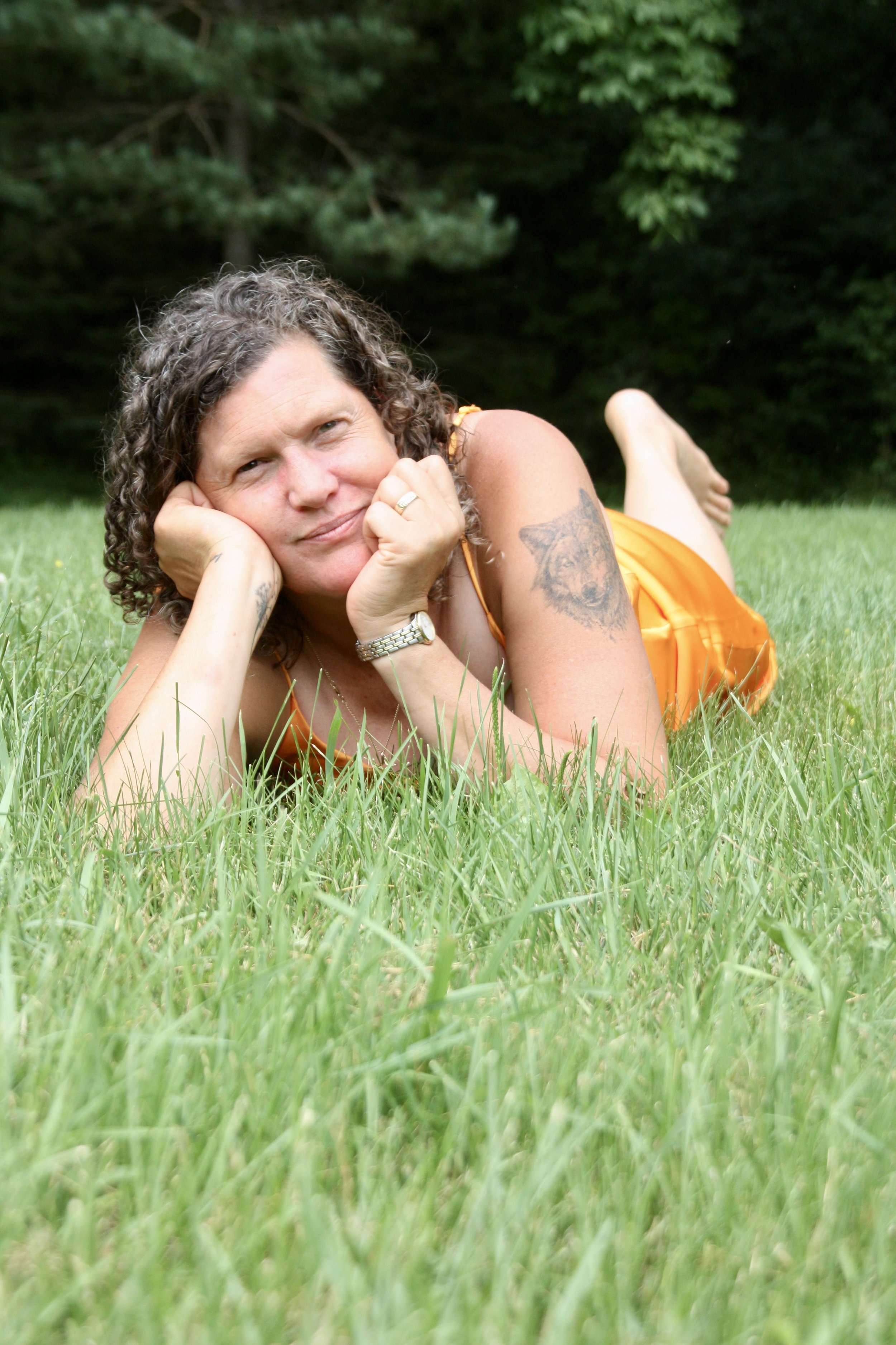 Woman lying in grass with her dog