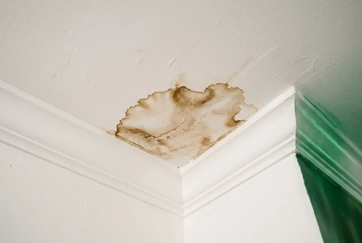 Discoloration and water staining on a residential living room ceiling drywall