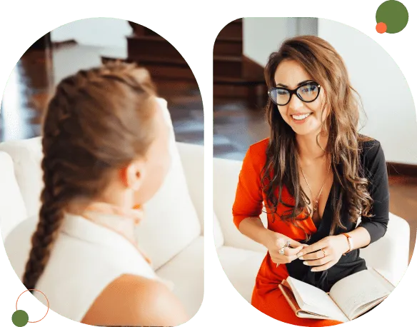 Two women engaged in a friendly conversation indoors.