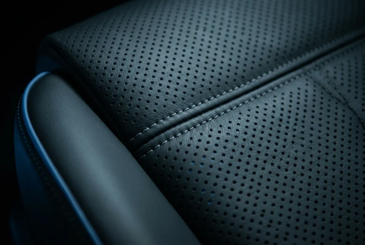Macro high-contrast shot of conditioned perforated leather and precision interior detailing