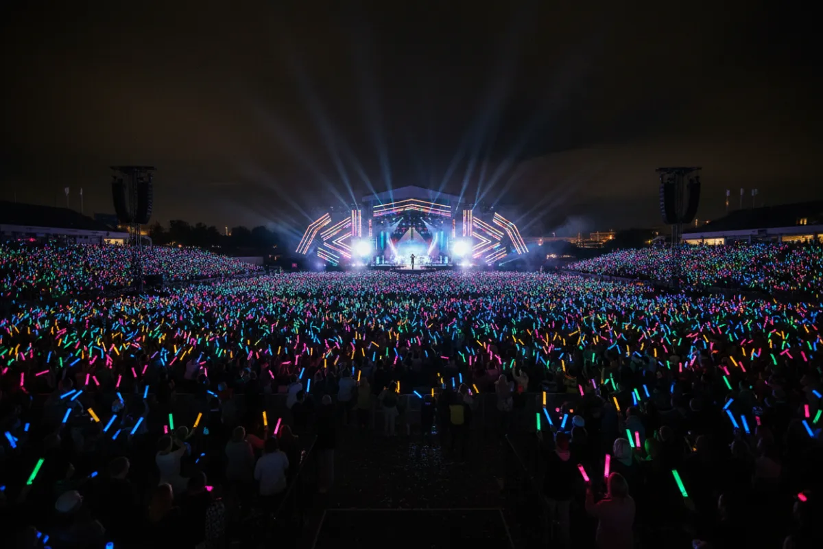 Landscape image of a crowd illuminated in synchronized light at an MMG festival.