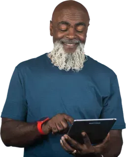 Older bearded man using a tablet to book a Medicare consultation
