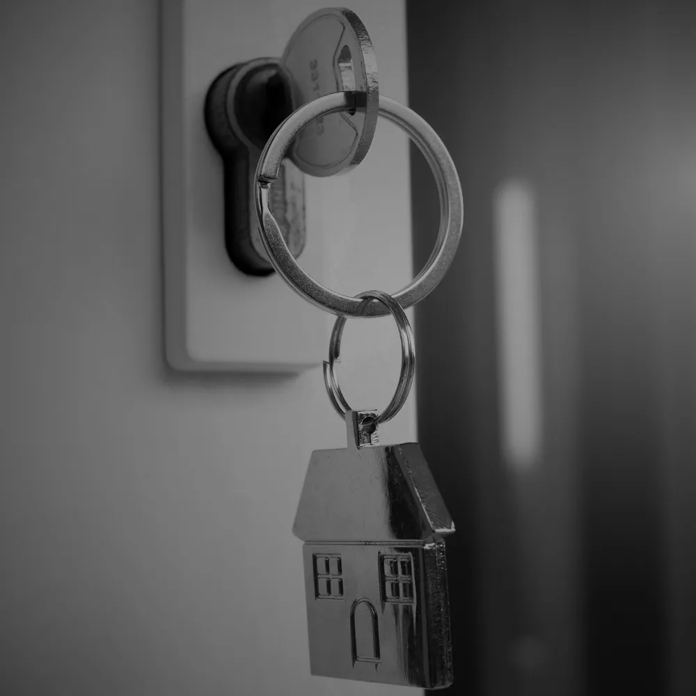 House key in a lock with a home-shaped keychain, symbolizing mortgage approval and homeownership in Alberta