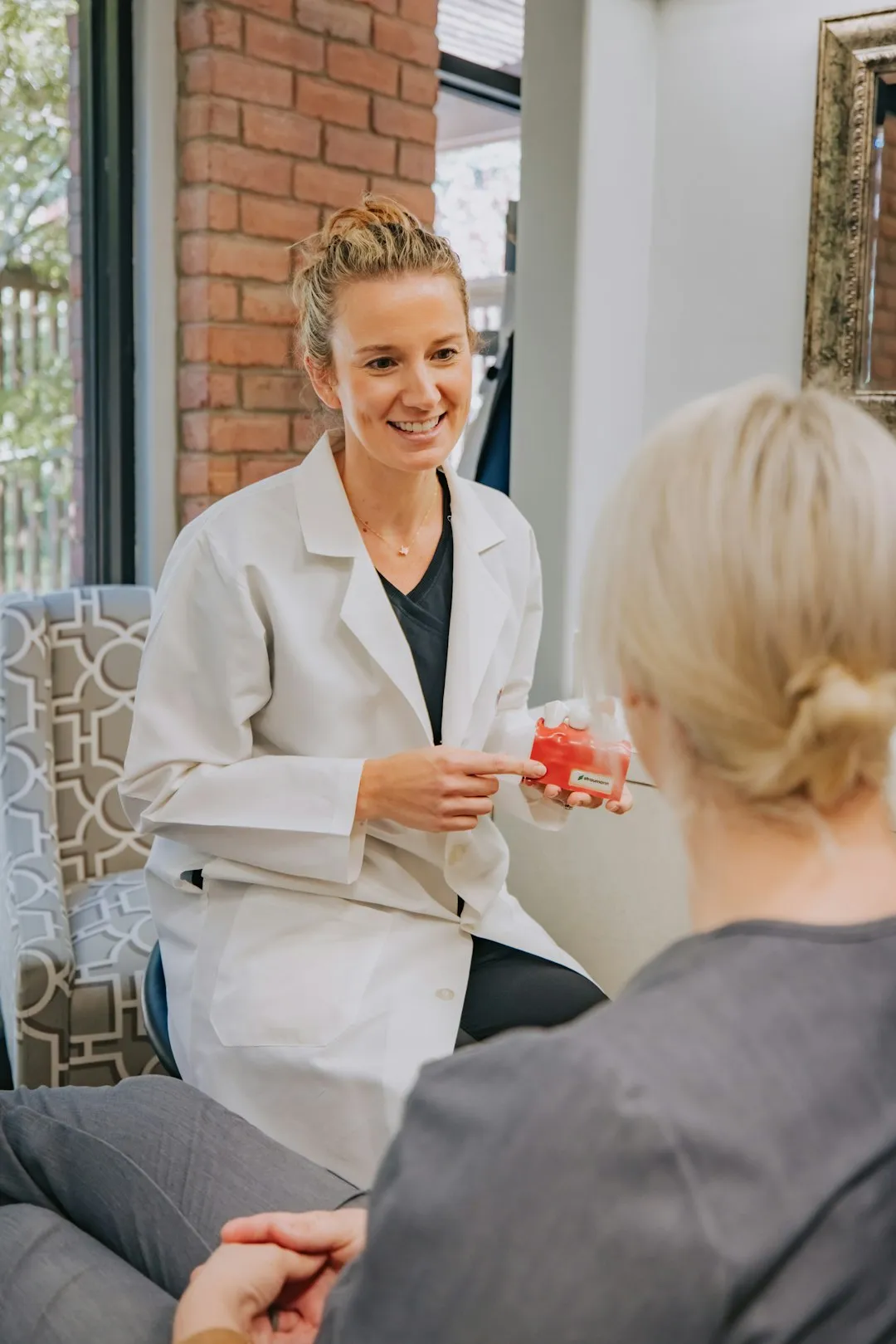 Female gynaecologist in a warm, private consultation room speaking with a relaxed female patient