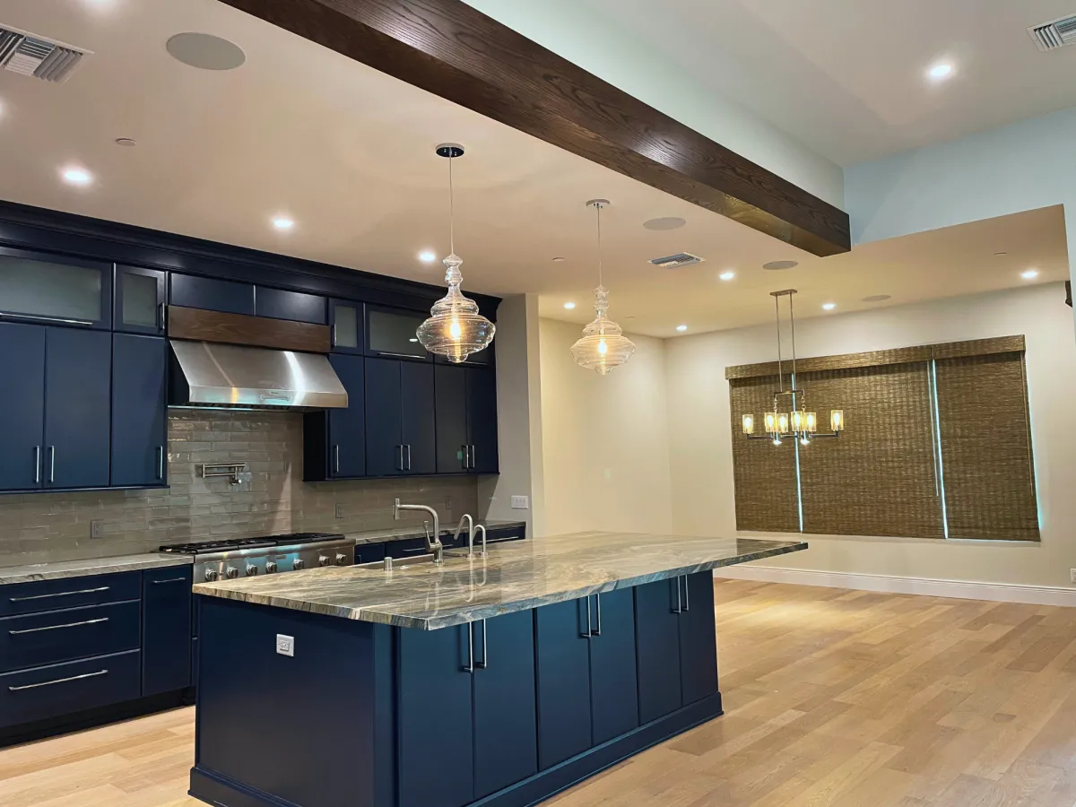 Elegant kitchen window dressed with faux wood blinds, Roman shades, and sheer shades for a stylish and functional touch.