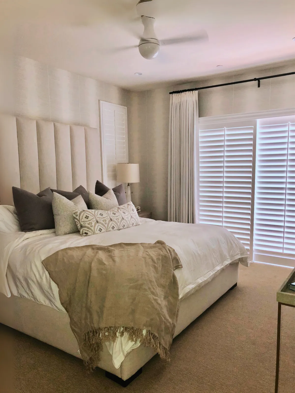 Elegant bedroom with layered drapery and light-filtering shades enhancing privacy and style