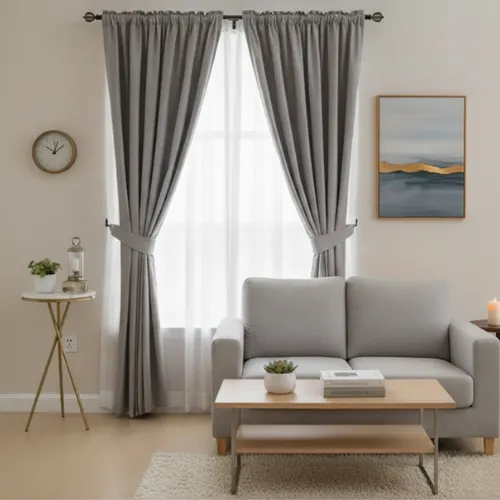 Window treatments with layered drapery and shades designed for sun exposure and light control in a bright coastal home