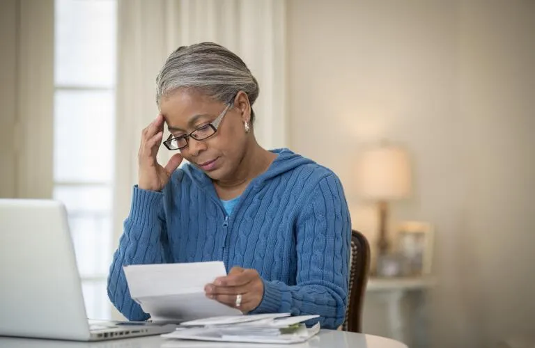 African American senior woman reviewing medical bills at home, highlighting Medicare coverage gaps after a hospital stay in Atlanta