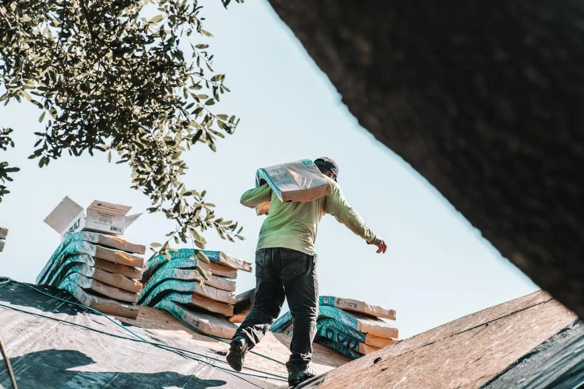 Contractor carrying roofing materials.