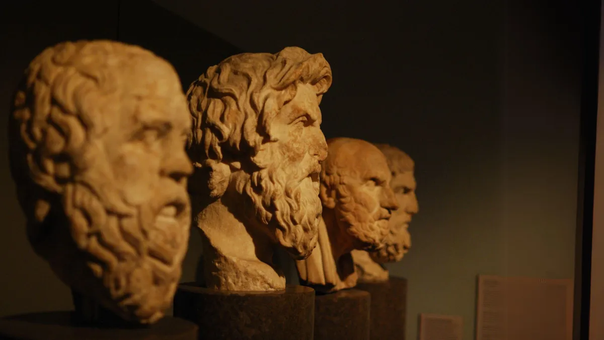 Four marble busts of Stoic philosophers are displayed in a row against a dark background