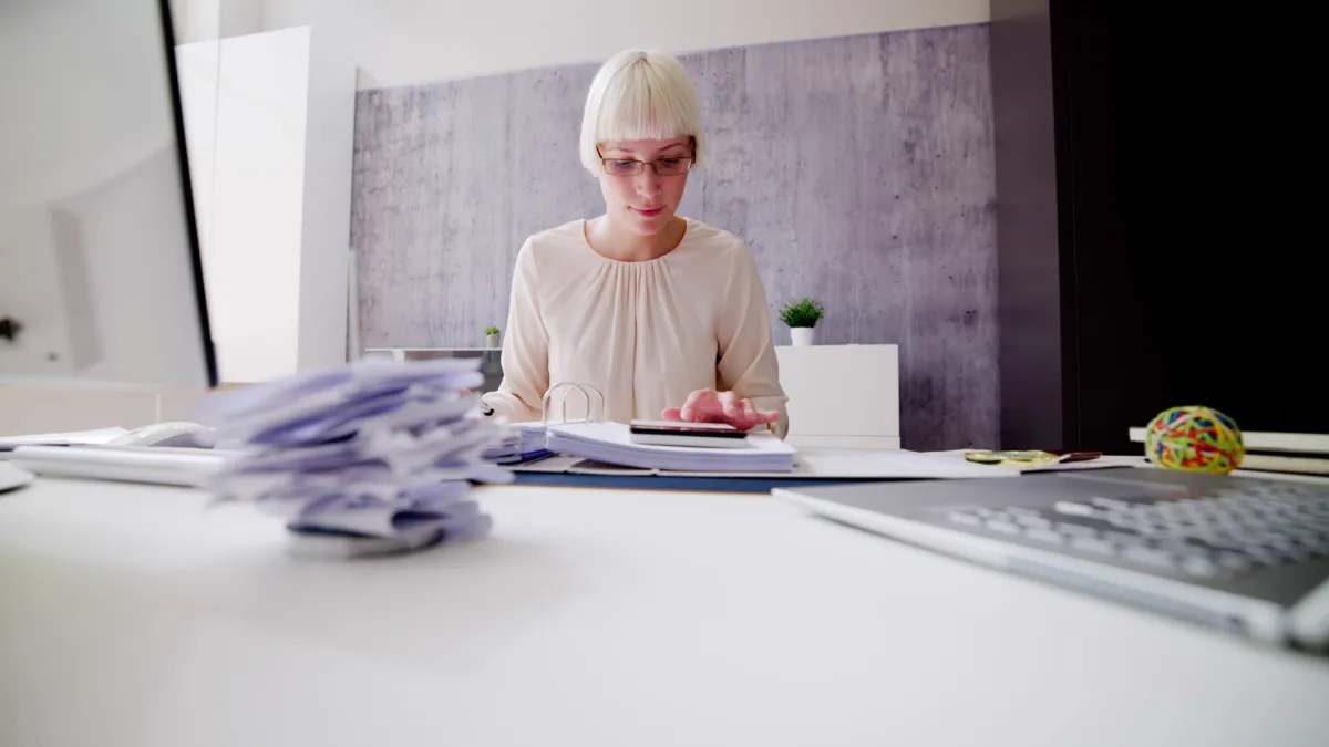 Corporate owner-employee with an SUV, reviewing tax documents and expense receipts at a desk