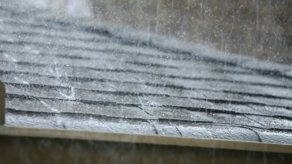 Heavy rainfall on a roof, highlighting the importance of gutter maintenance during Mildura’s storm season.