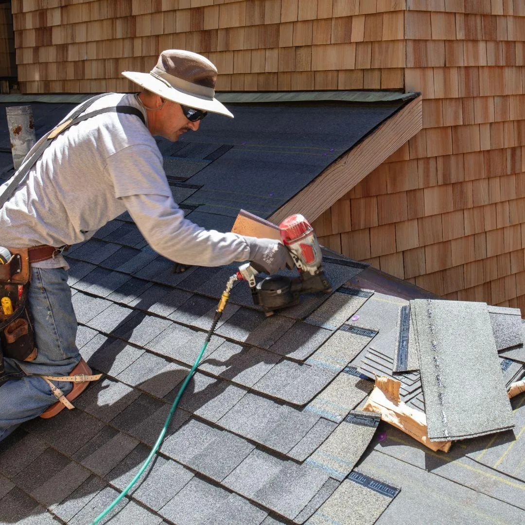 Professional roofers installing a new asphalt shingle roof on a residential home, ensuring durability, weather resistance, and long-term protection.