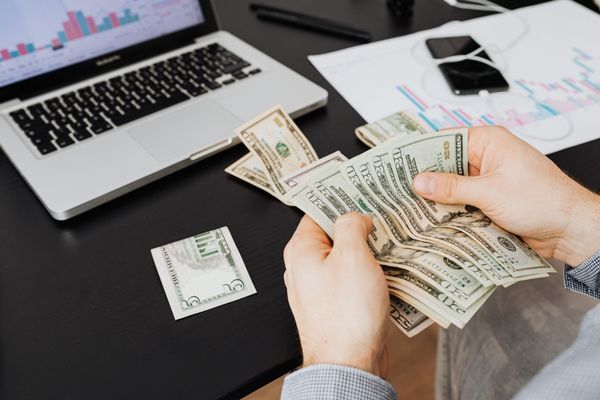 Counting cash in front of a computer