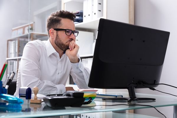 Young man looking at student loan payoff strategies on computer screen