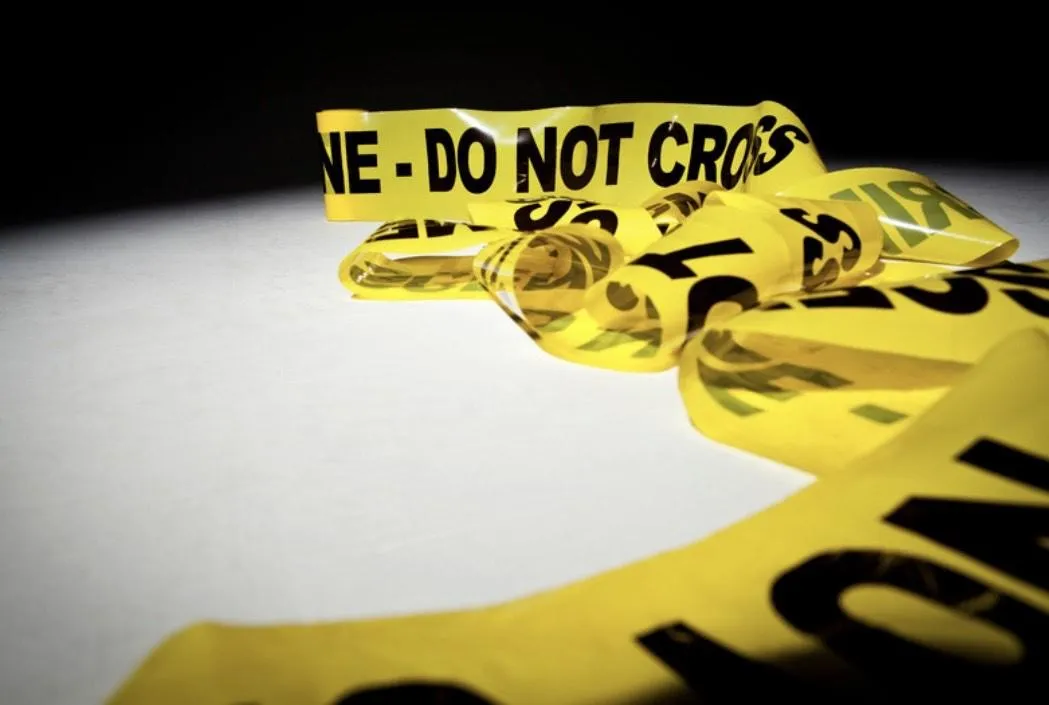 Crossing the lines, yellow do not cross tape is trampled to the ground