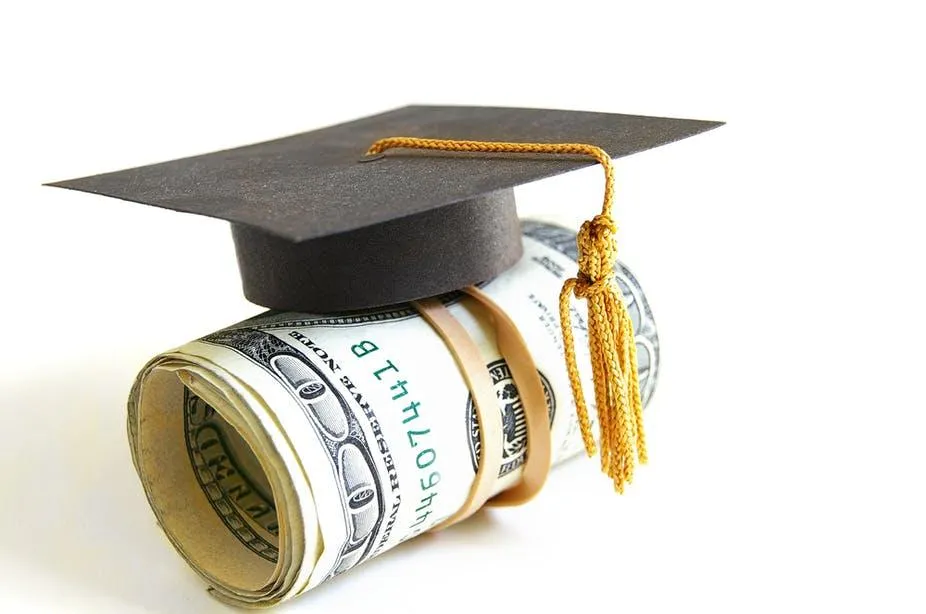Hundered dollar bills beneath a graduation cap
