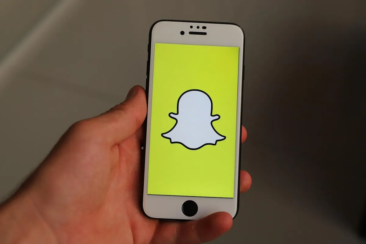 Hand holding a mobile phone with the snapchat logo displayed