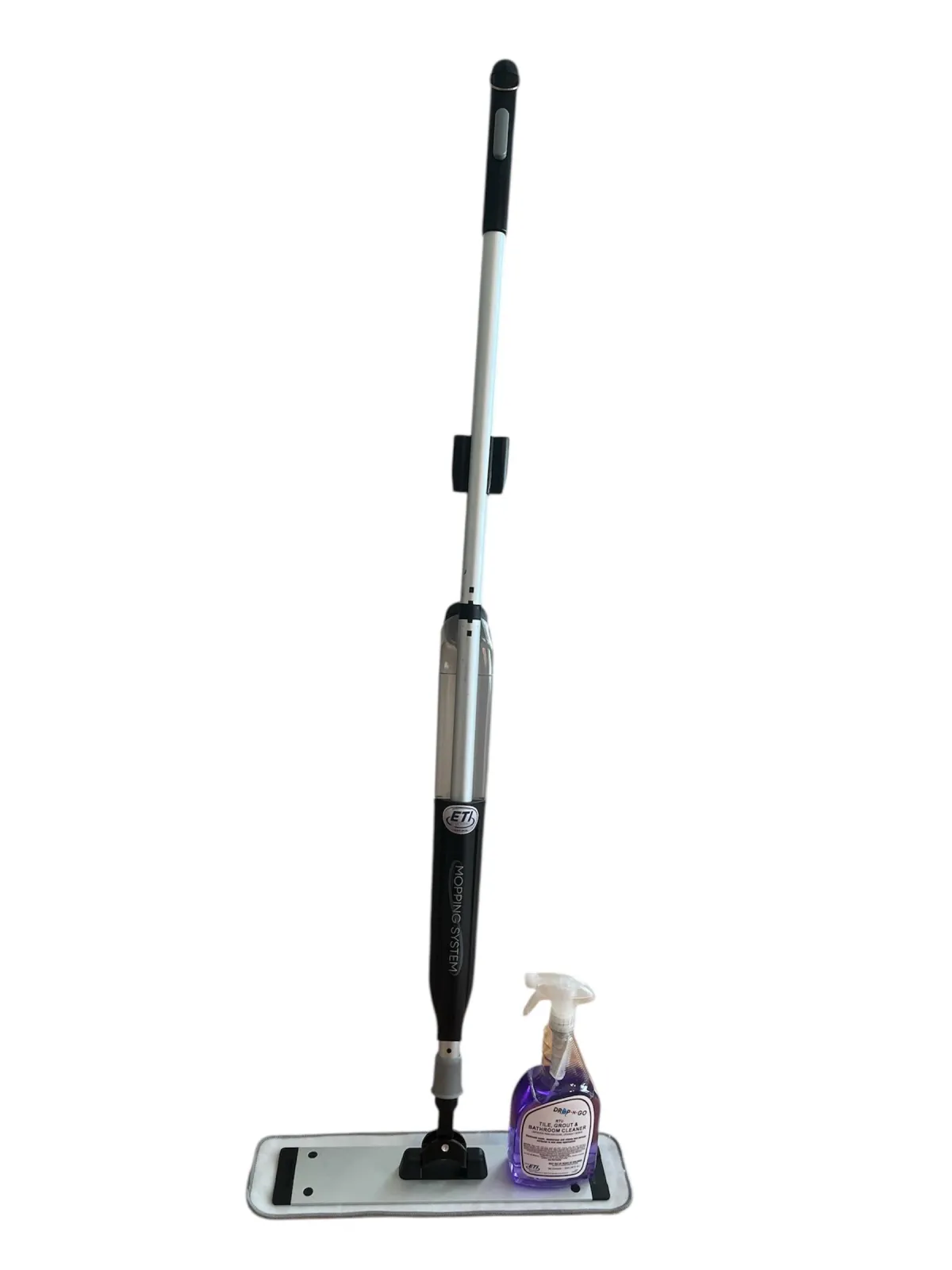 A sleek Drop-N-Go mopping system bottle with a concentrated cartridge being inserted into the chamber, set against a sparkling clean floor in a modern vacation rental.