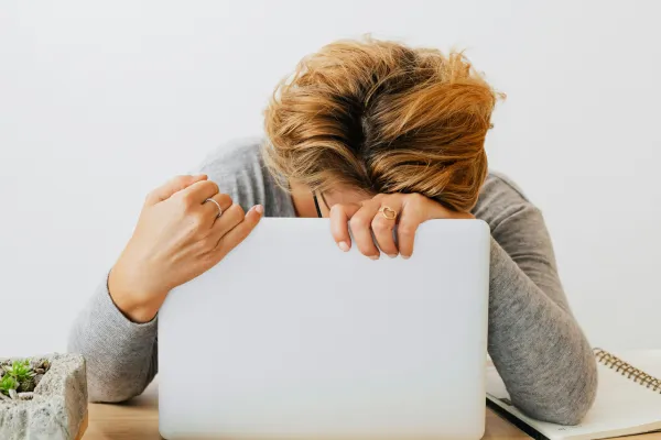 Woman hugging her laptop exhausted