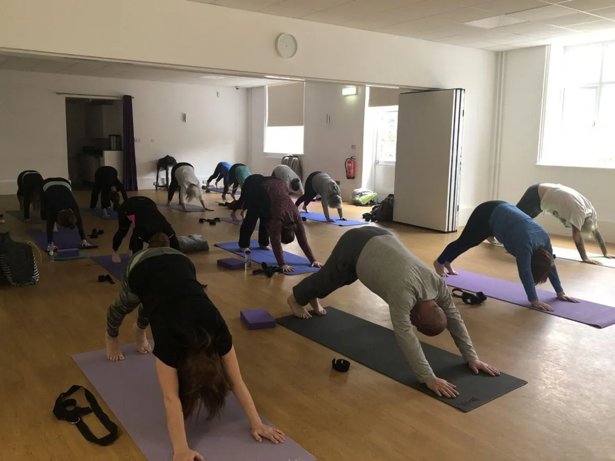 The yoginis and yogis of John Godber Centre, Hucknall Nottingham strengthening their shoulders in downward facing dog
