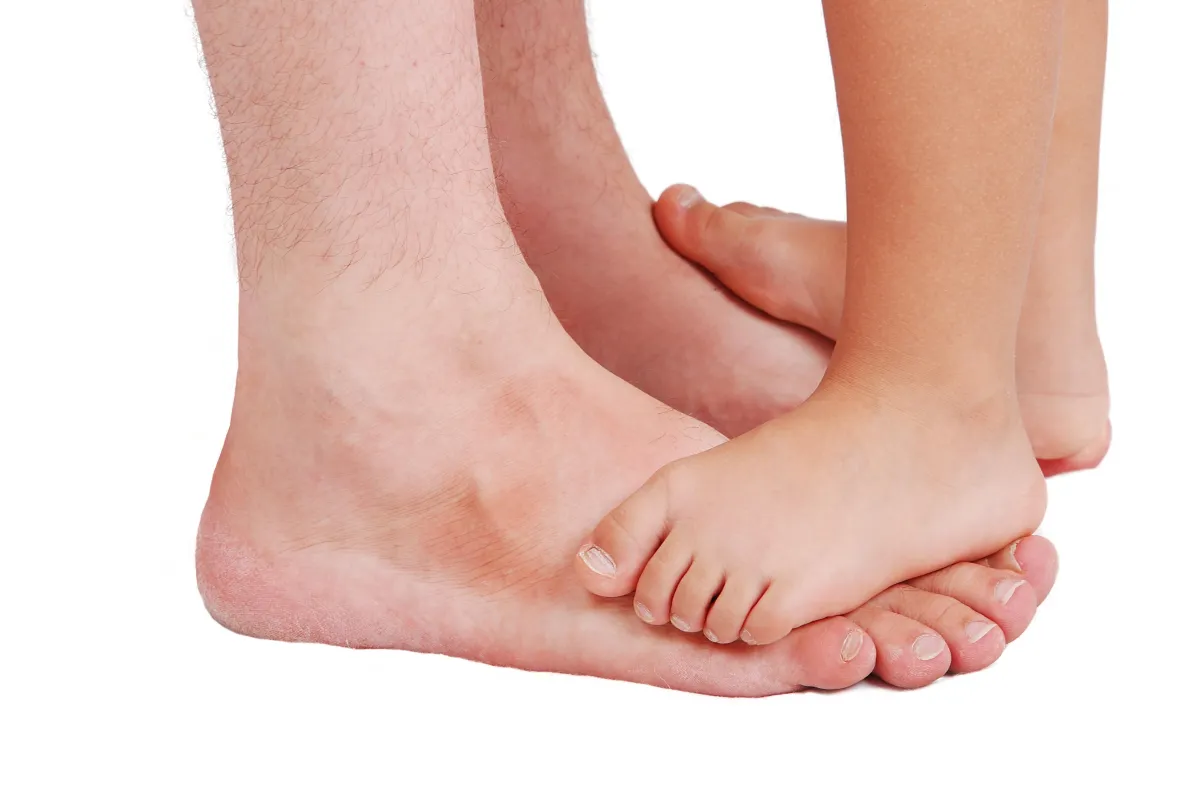 Child standing on adults feet. We Fix Feet, Beeston and Ilkeston