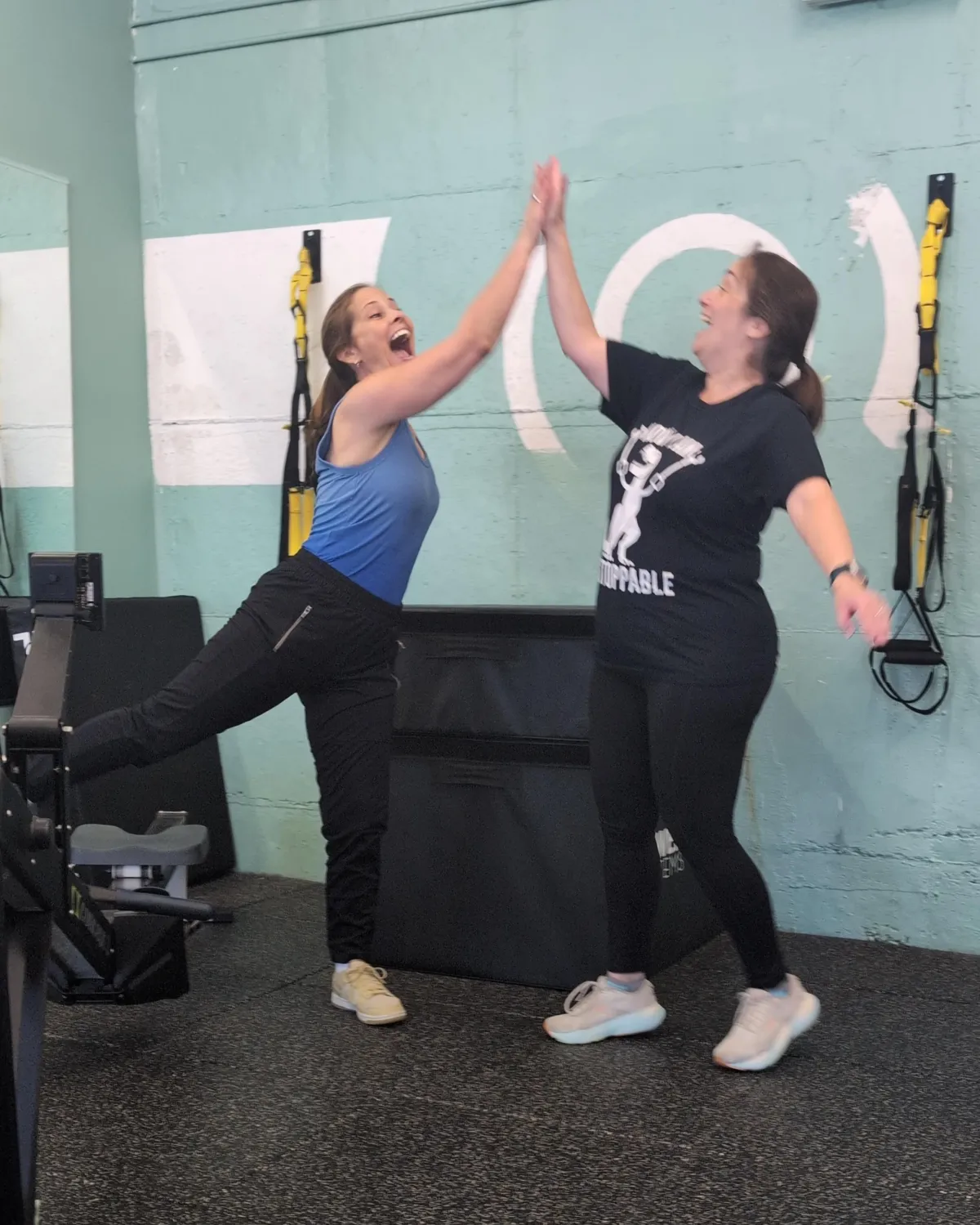 Amanda and Kim high-five after their high-intensity conditioning finisher is over!
