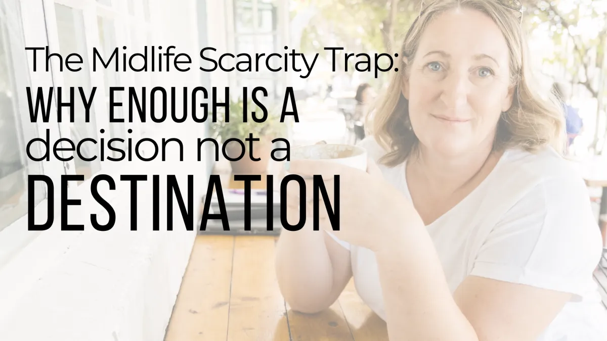Midlife woman sitting at a café table, holding a cup of coffee and smiling calmly, with text overlay reading “The Midlife Scarcity Trap: Why Enough Is a Decision, Not a Destination.