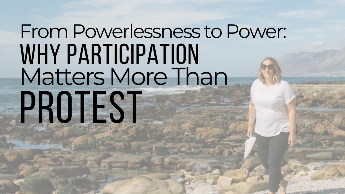 Woman walking along a rocky shoreline, representing midlife reflection, personal power, and conscious participation.