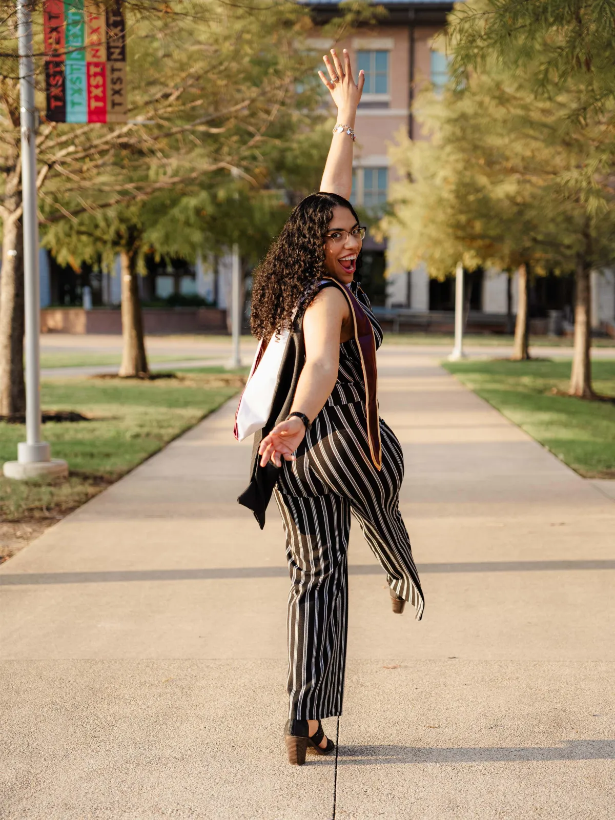 A proud Texas State University graduate takes a celebratory walk on campus.
