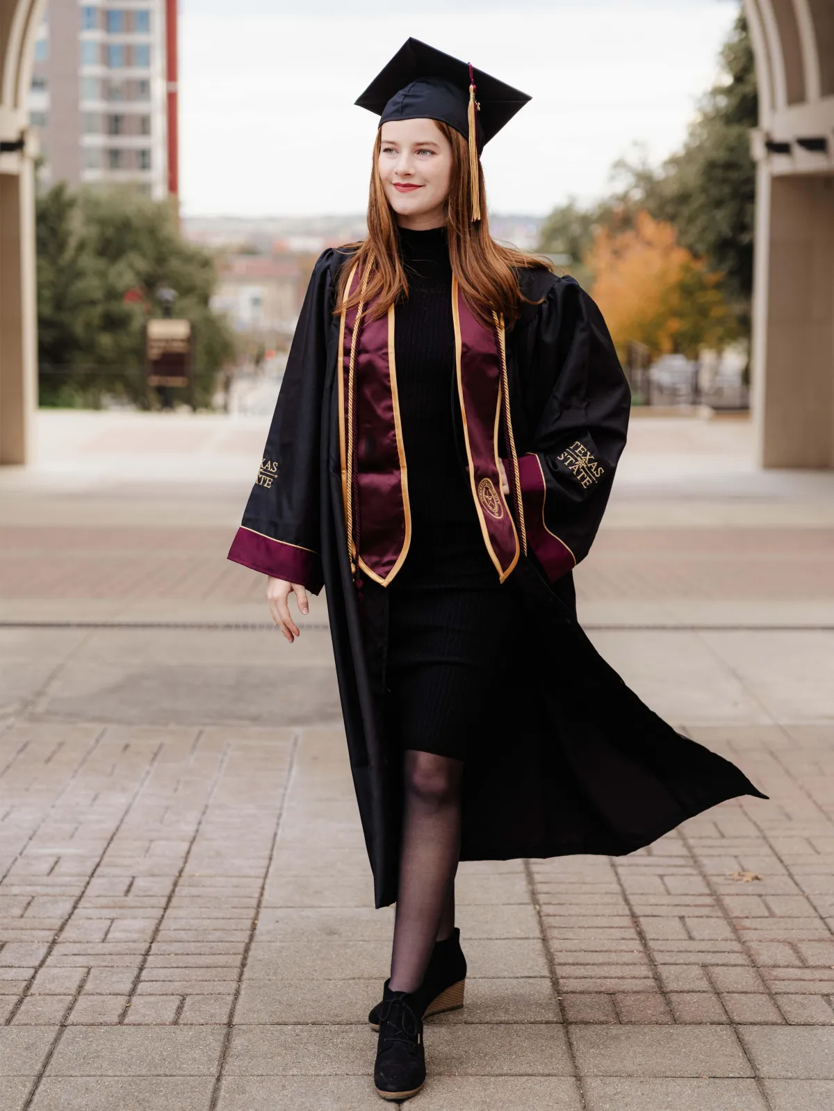 Texas State University graduate celebrating their achievement on campus, San Marcos, TX.