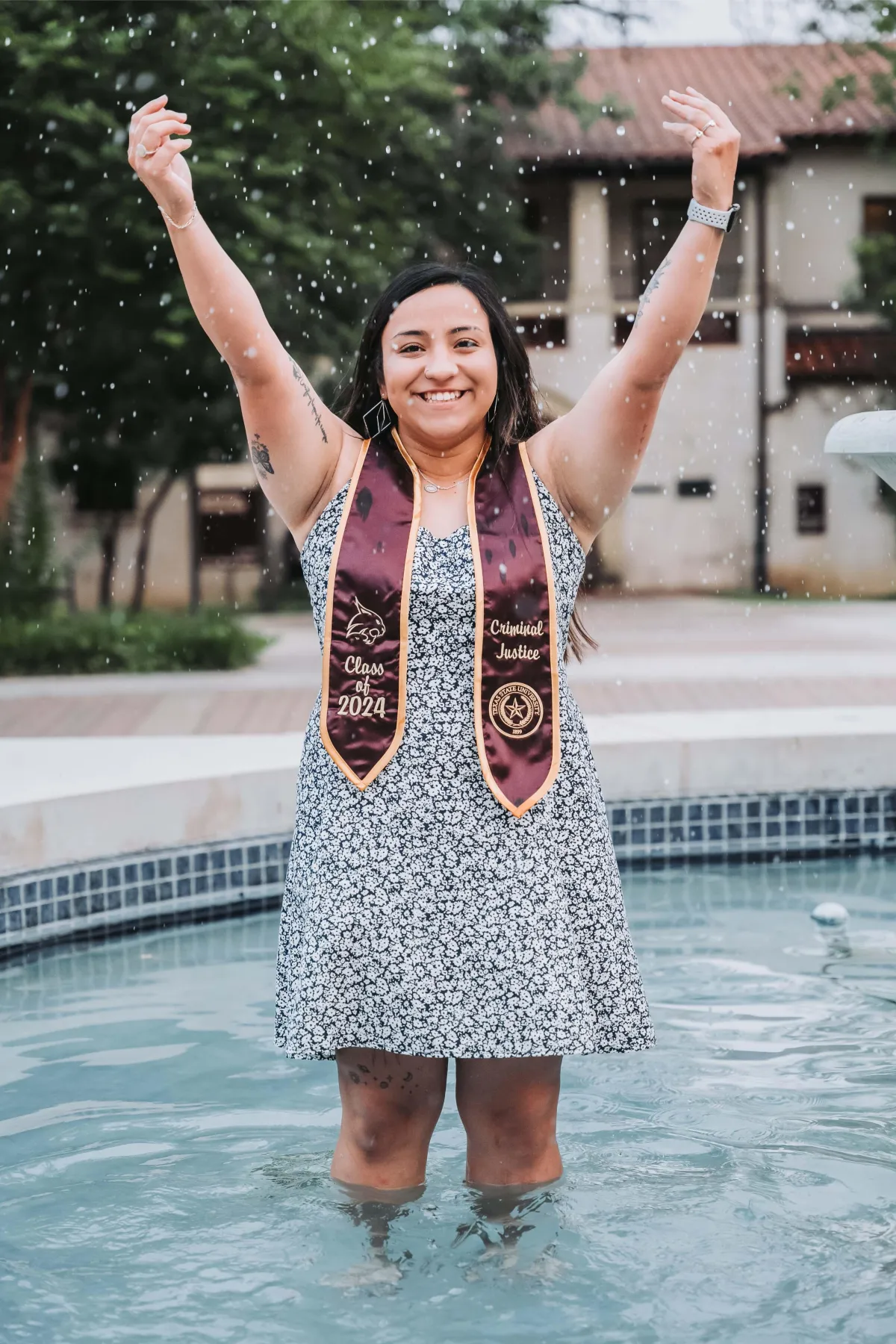 Texas State University graduate walking towards their future, captured in a graduation portrait.