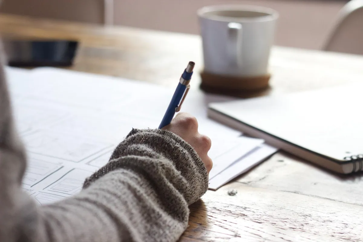 person writing at desk