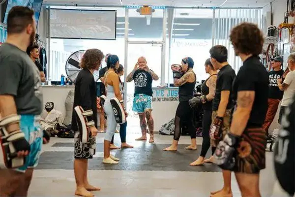 A class of Muay Thai at Stadium MMA gym in Port Orange Florida. The class are being shown a strike from the head coach.