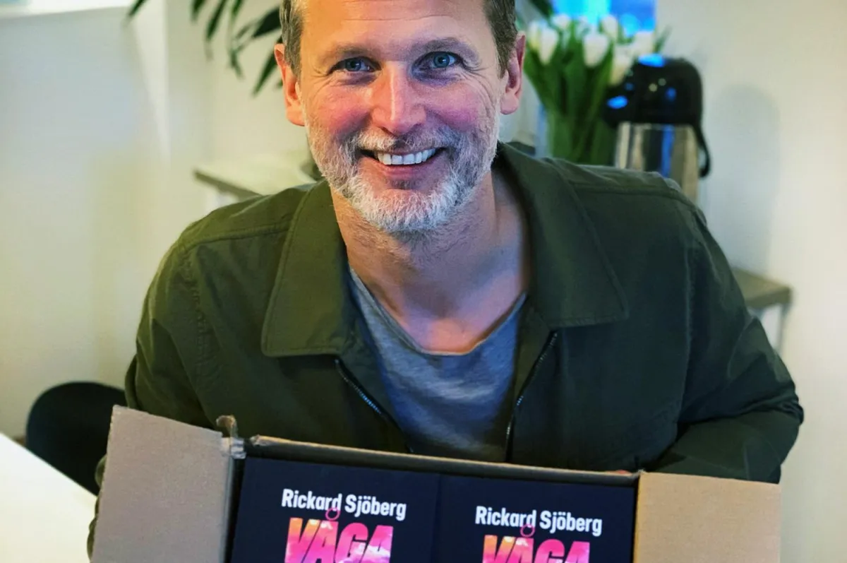 Rickard framför en kartong med boken Våga vara modig.