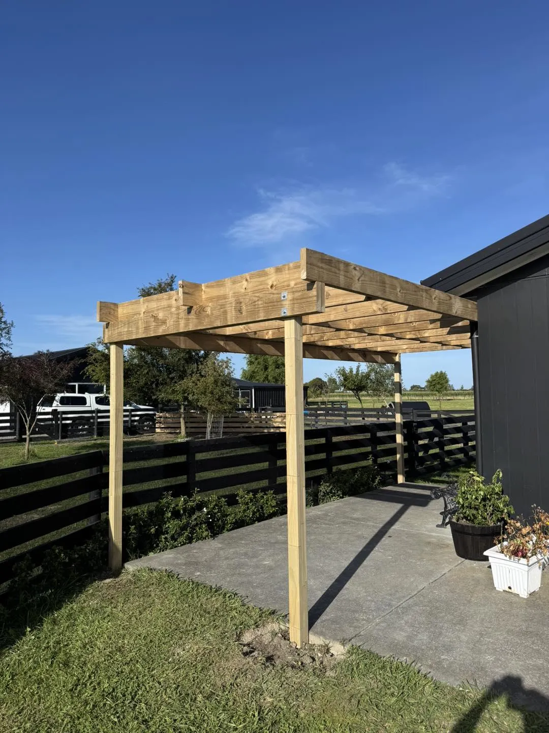 Timber pergola frame construction in progress beside a house, illustrating pergola building services in Hawke's Bay by Mitch's Maintenance
