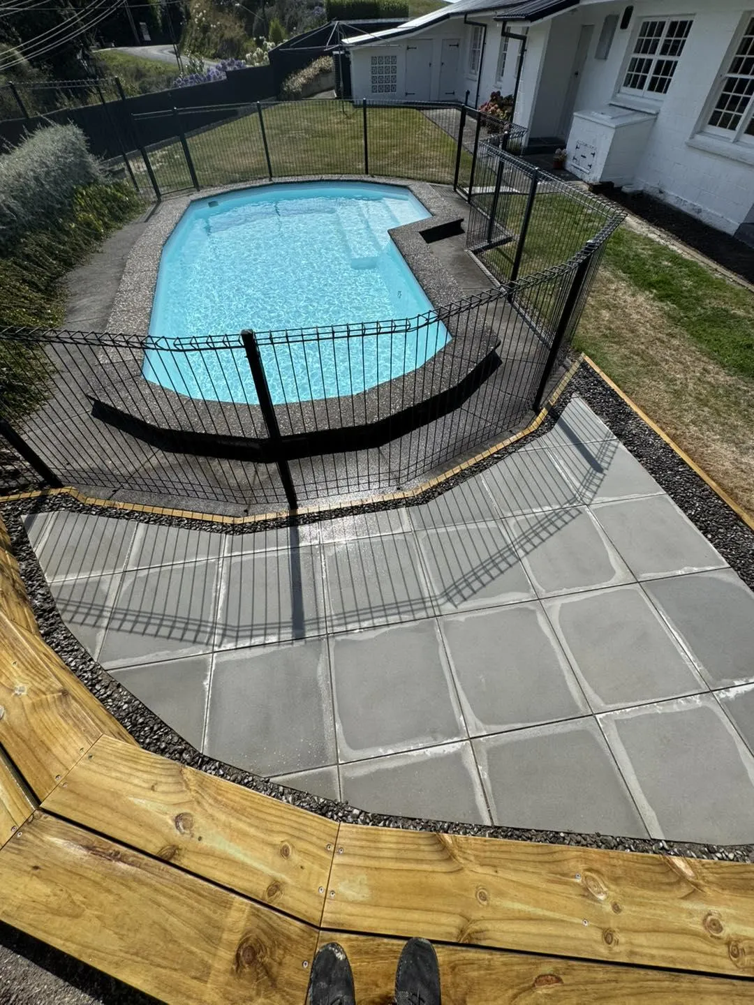 Swimming pool area surrounded by timber retaining walls and paved walkway, demonstrating landscaping and outdoor improvement services in Hastings, Hawke's Bay by Mitch's Maintenance