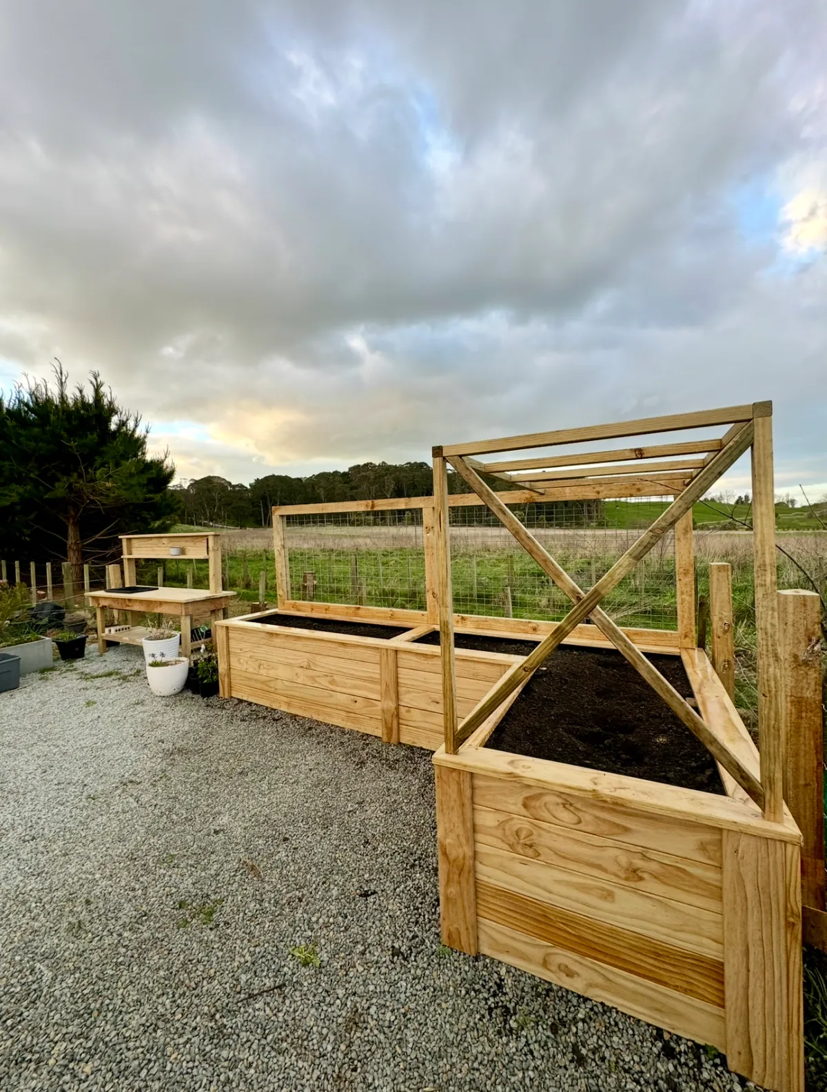 New timber planter boxes and retaining structures on gravel driveway, showcasing planter box installation and retaining wall building in Hawke's Bay by Mitch's Maintenance