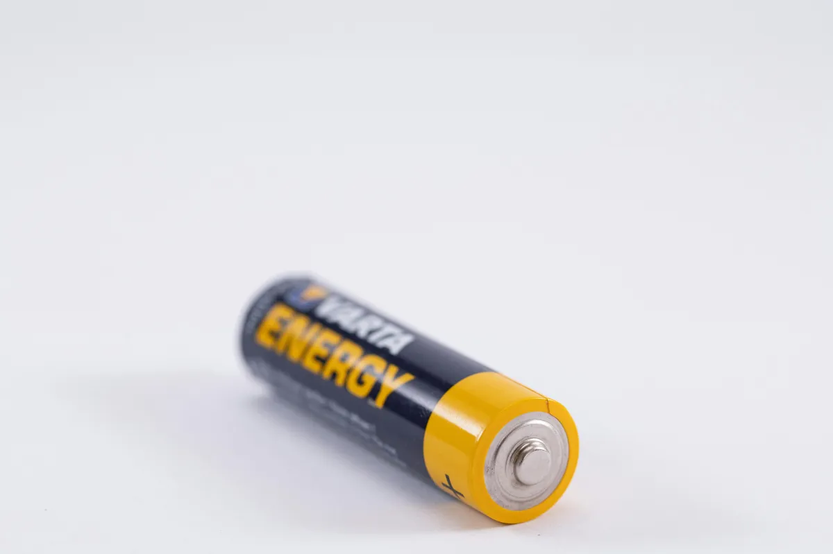 black and yellow battery lying on white surface