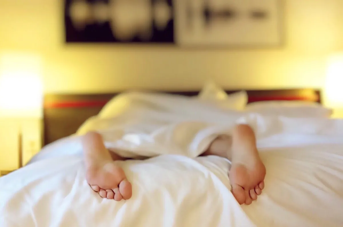 feet hanging over bed