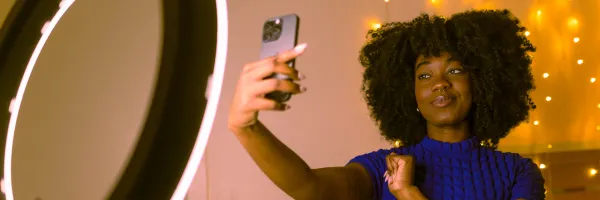 Woman taking a selfie in front of a ring light