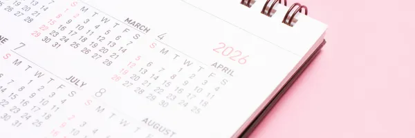Close up of a 2026 calendar on a pink background.