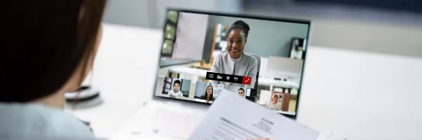 Financial Director sitting at a laptop in a virtual meeting with a business.
