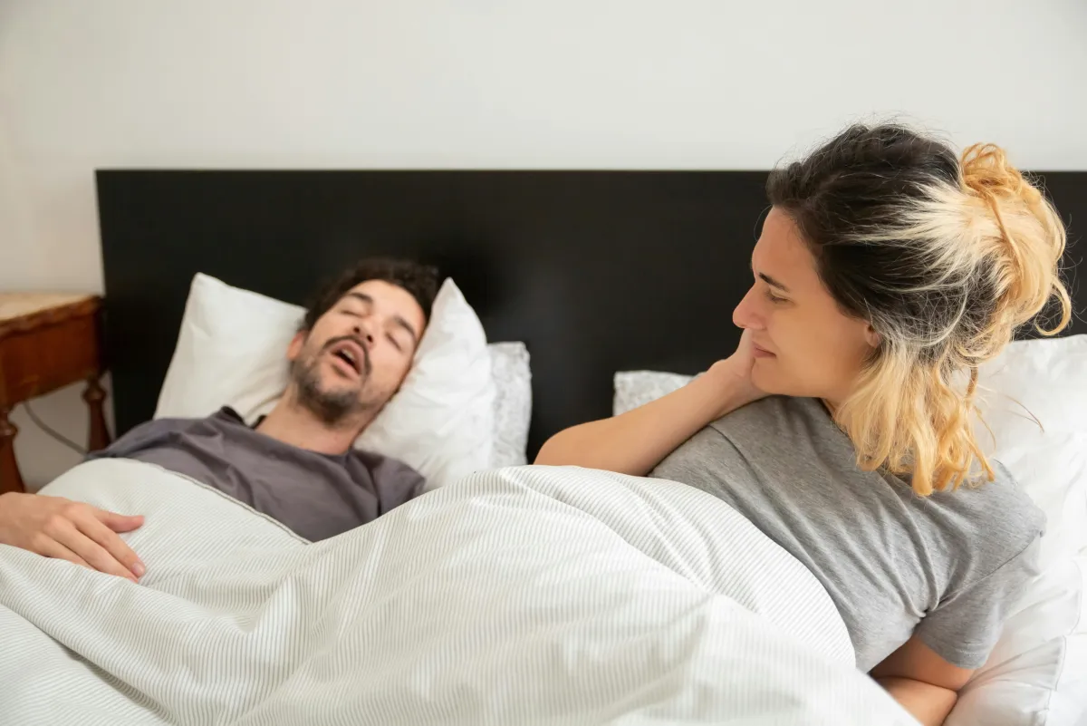 Man snoring while sleeping, possible sign of sleep apnea