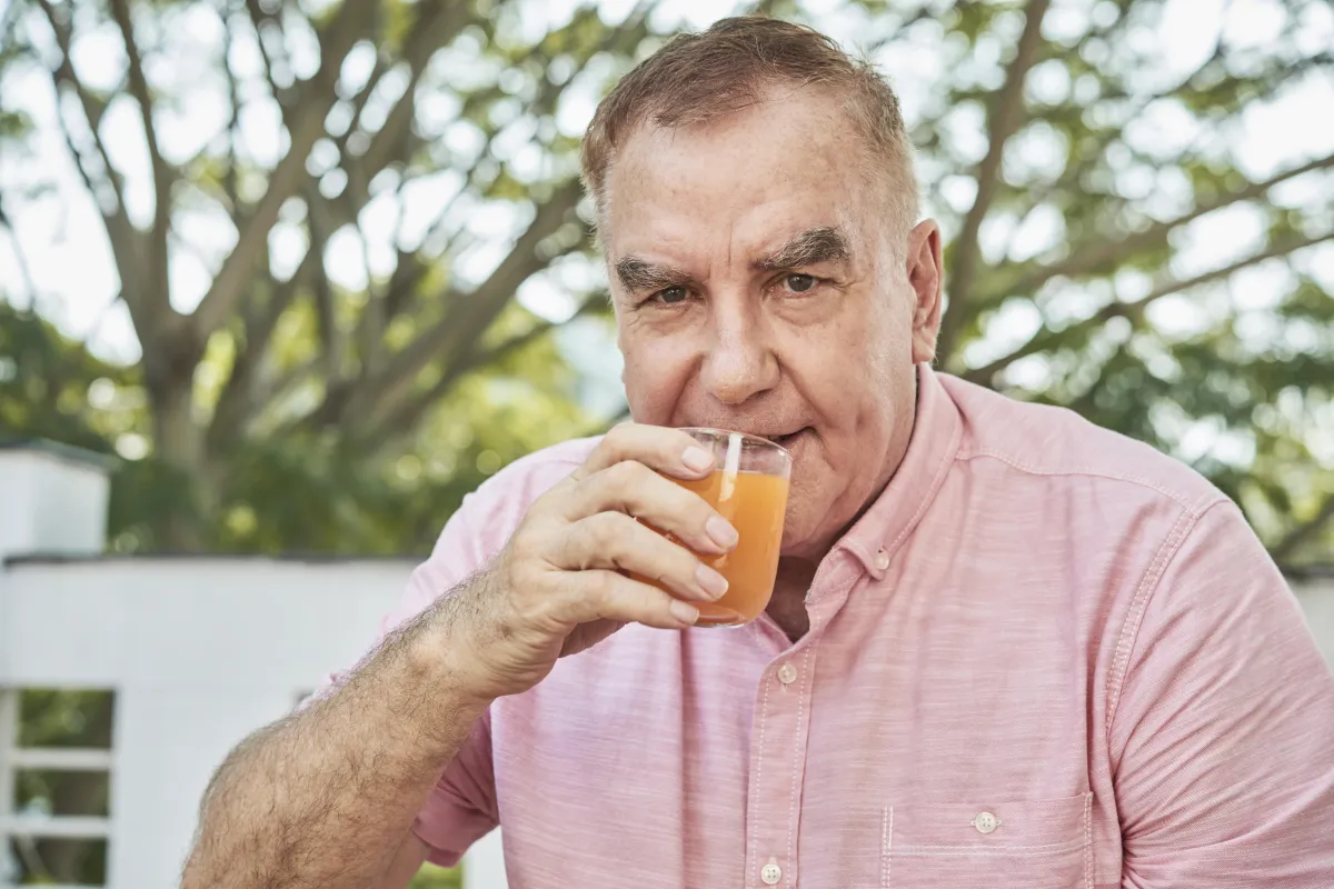 Aged man drinking juice